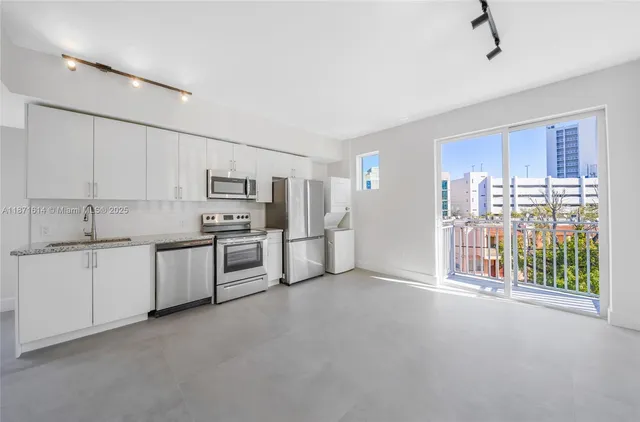 a large kitchen with white cabinets and stainless steel appliances