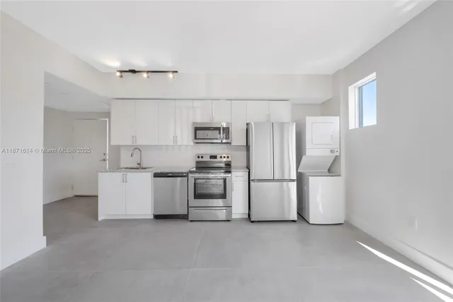 a kitchen with white cabinets and stainless steel appliances