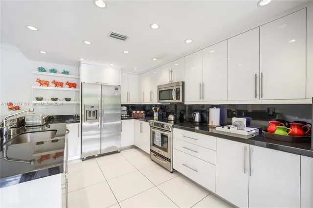 a kitchen with stainless steel appliances granite countertop a refrigerator sink and cabinets