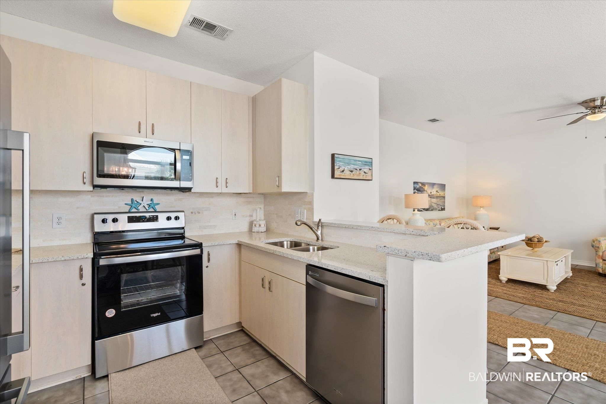 3575 Bayou Road, Unit A 10 Orange Beach, AL 36561 - Photo 11 of 31 Kitchen appliances with stainless steel finishes, decorative marble backsplash, kitchen peninsula, new nickel finished, solid brass cabinet hardware , and basin sink