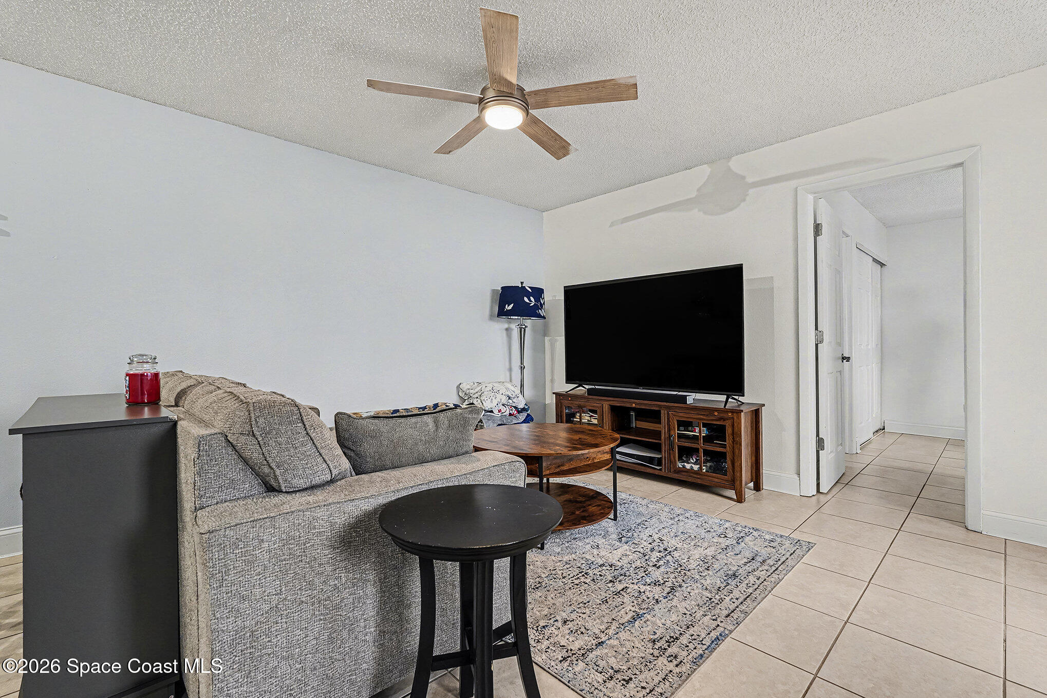 1491 Sheafe Avenue Northeast, Unit 104 Palm Bay, FL 32905 - Photo 2 of 19 a living room with furniture and a flat screen tv