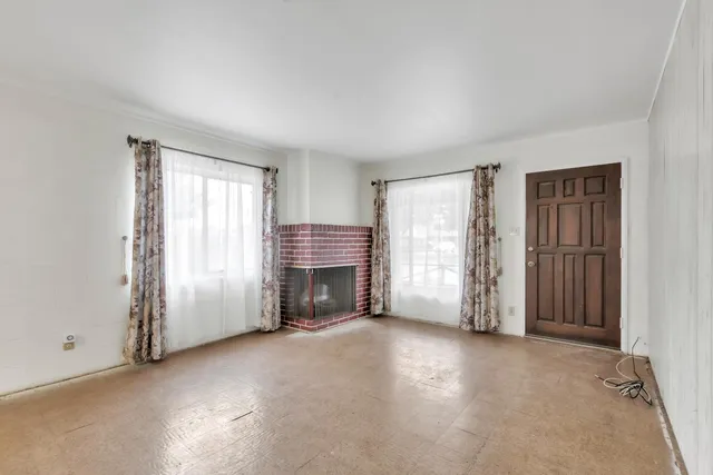 an empty room with fireplace and windows