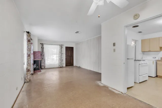 a view of a kitchen with refrigerator and window
