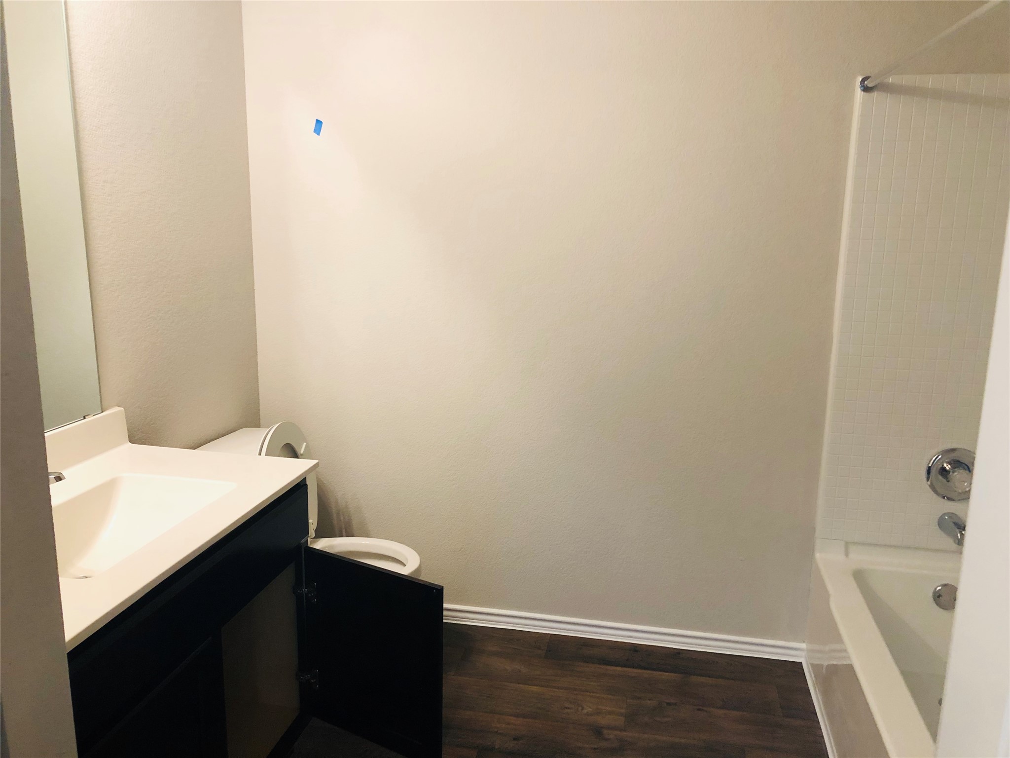 5712 Ronee Leah Drive Austin, TX 78724 - Photo 11 of 14 The bathroom features dark wood-look flooring, a white vanity with a single sink, and a toilet