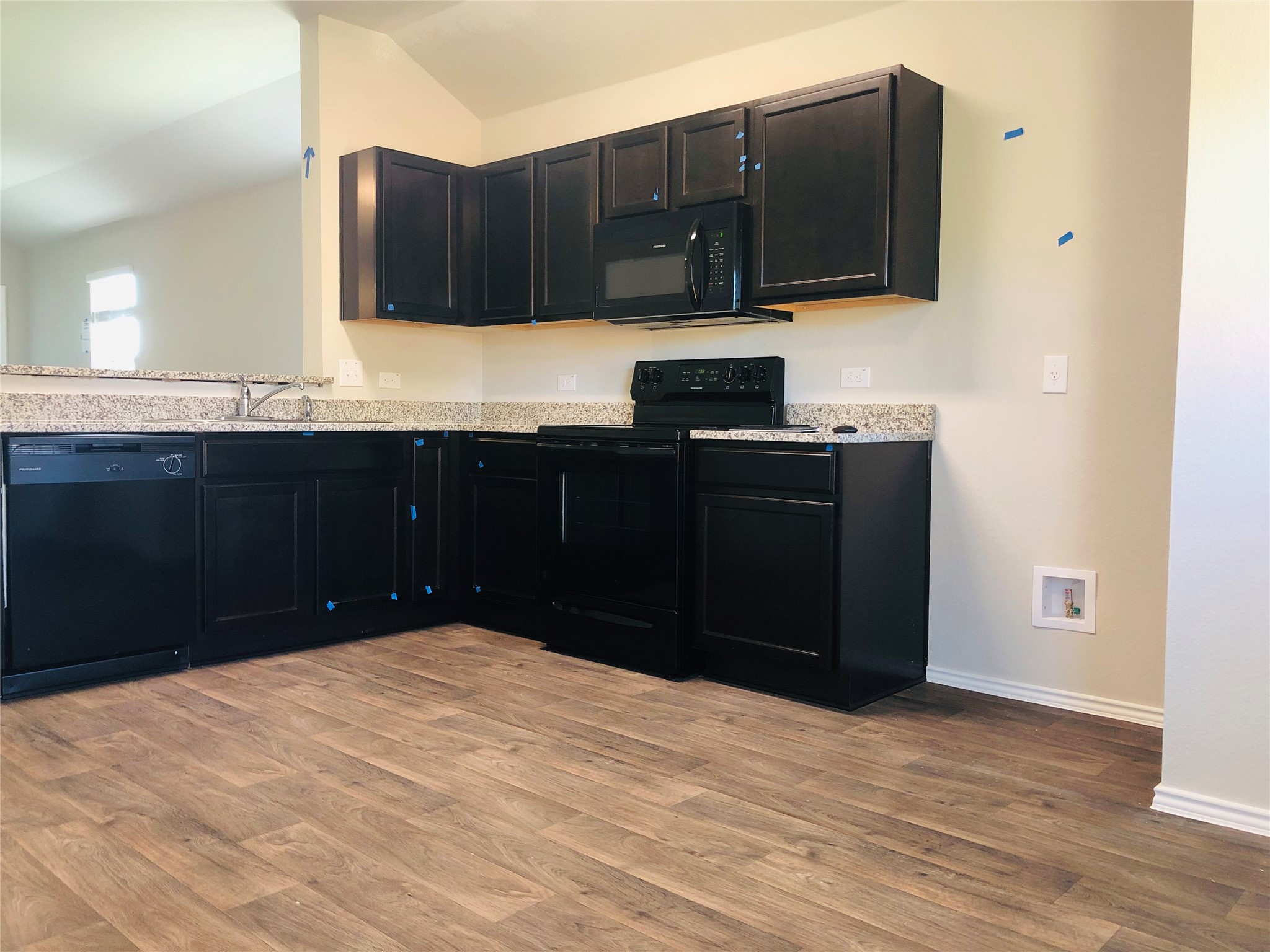 5712 Ronee Leah Drive Austin, TX 78724 - Photo 4 of 14 The kitchen features dark cabinetry, granite countertops, a built-in microwave, an electric range, and a dishwasher