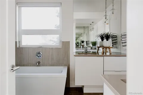 a bathroom with a bathtub a sink and a window