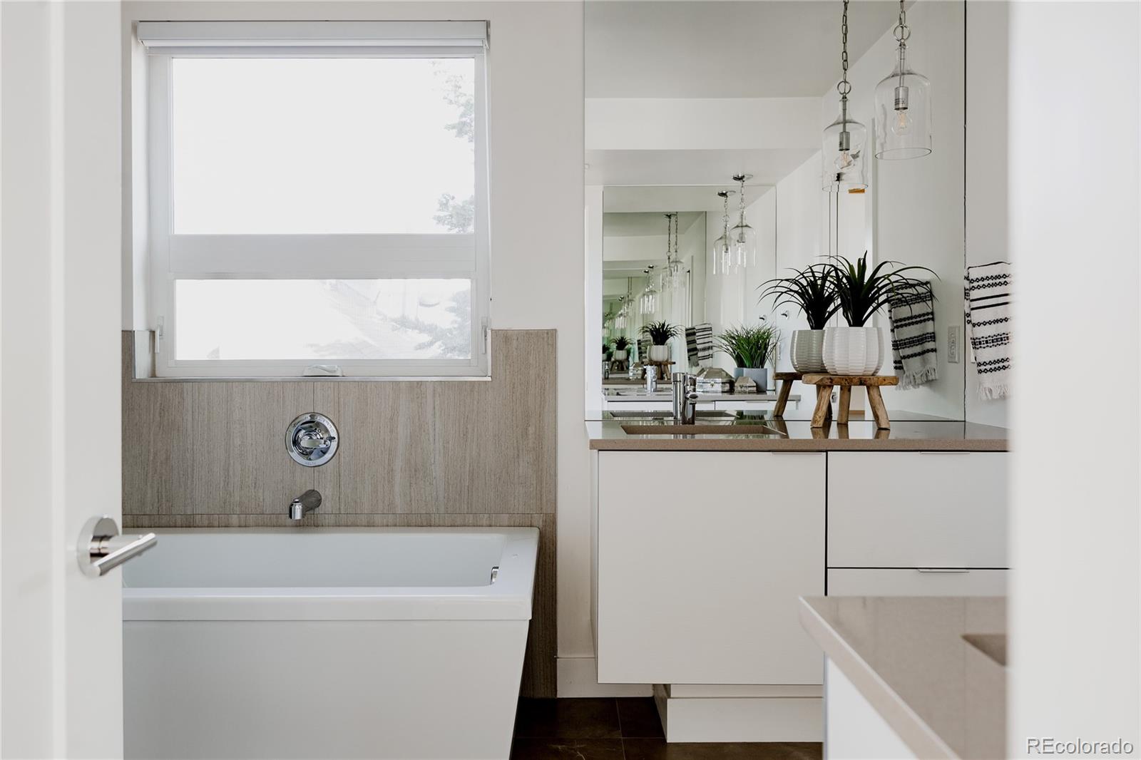 3724 Quivas Street Denver, CO 80211 - Photo 17 of 46 a bathroom with a bathtub a sink and a window