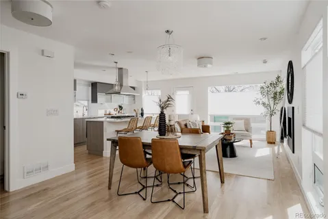 a dining room with stainless steel appliances kitchen island granite countertop a dining table and chairs