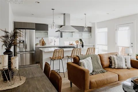 a living room with furniture a refrigerator and a table