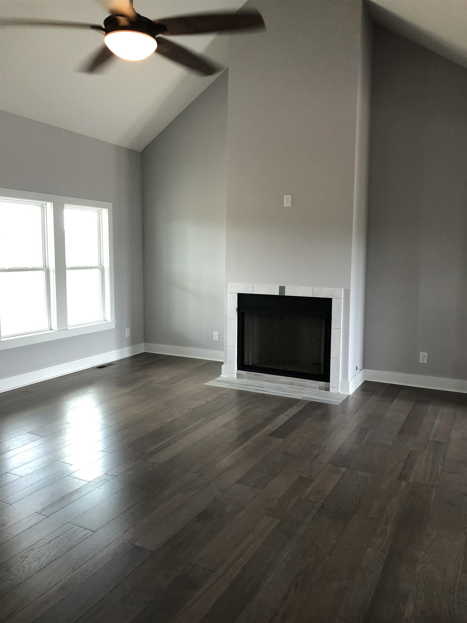 409 Halltown Road Cottontown, TN 37048 - Photo 20 of 25 an empty room with floor to ceiling windows and fireplace