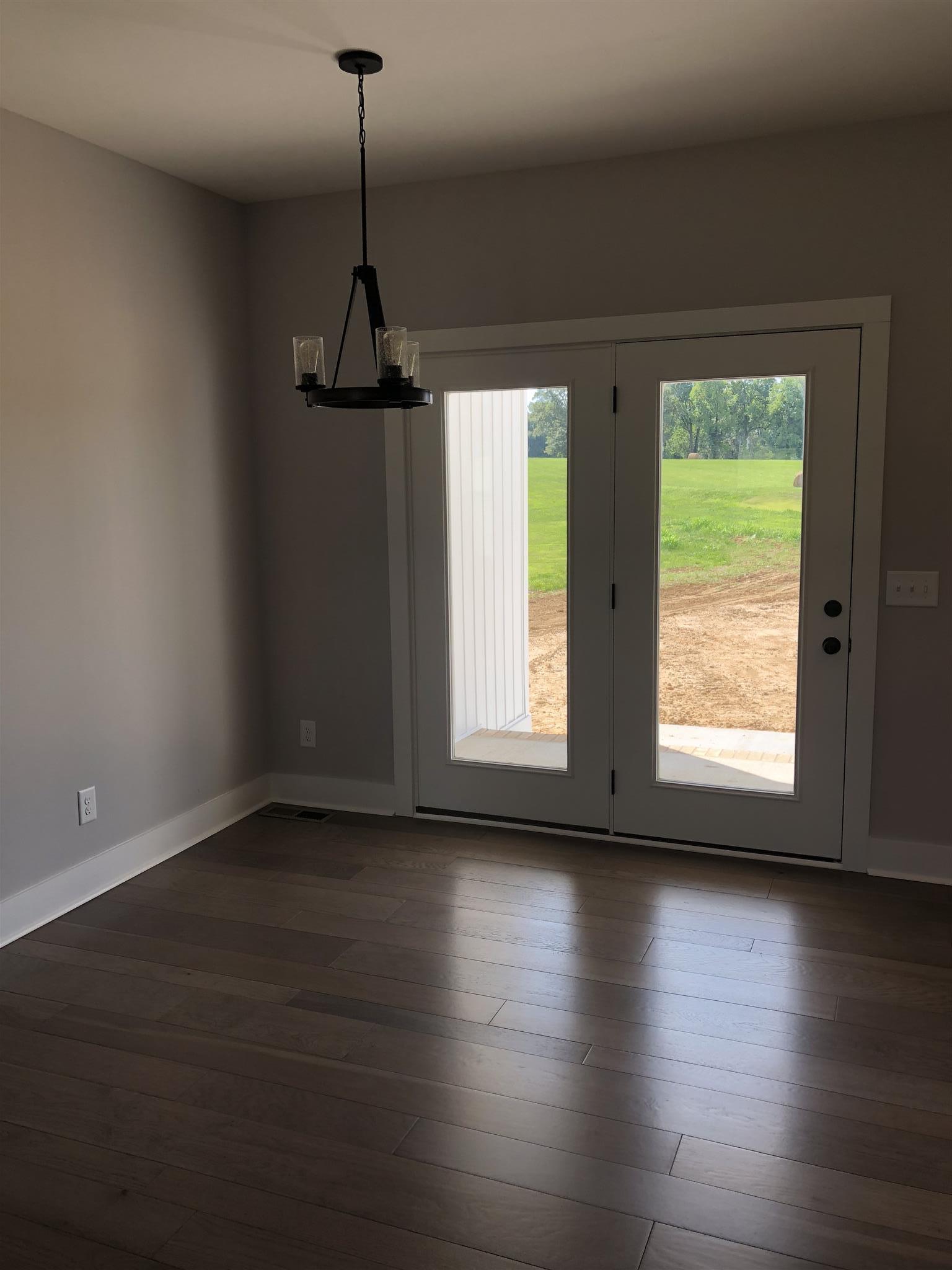 409 Halltown Road Cottontown, TN 37048 - Photo 4 of 25 a view of an empty room with wooden floor and a window