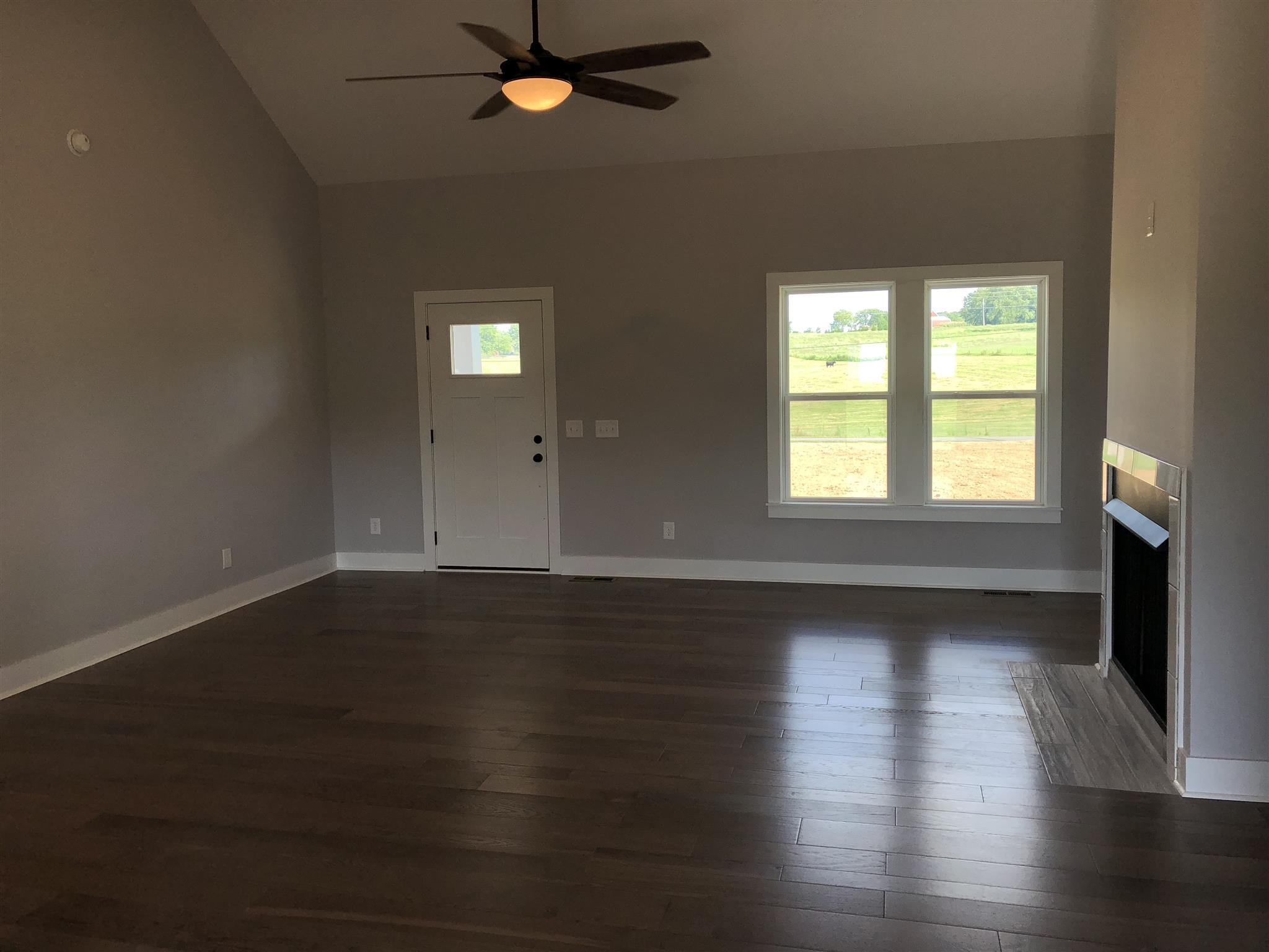 409 Halltown Road Cottontown, TN 37048 - Photo 5 of 25 a view of an empty room with wooden floor and a window