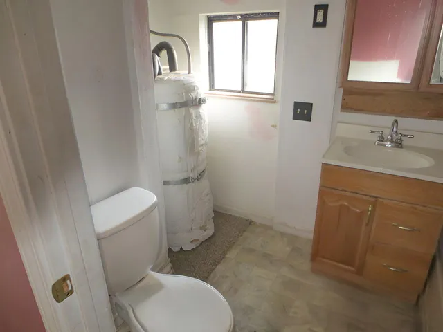 a bathroom with a toilet sink and mirror