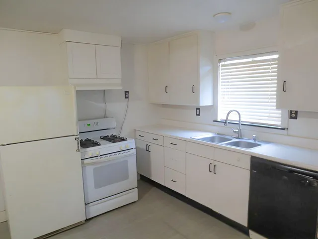 a kitchen with white cabinets and white appliances