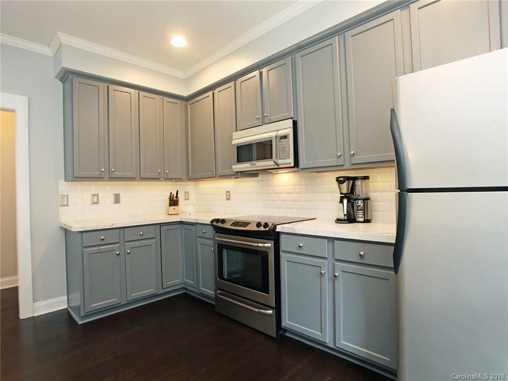 9399 Founders Street, Unit 164 Fort Mill, SC 29708 - Photo 11 of 36 a kitchen with granite countertop white cabinets and white appliances