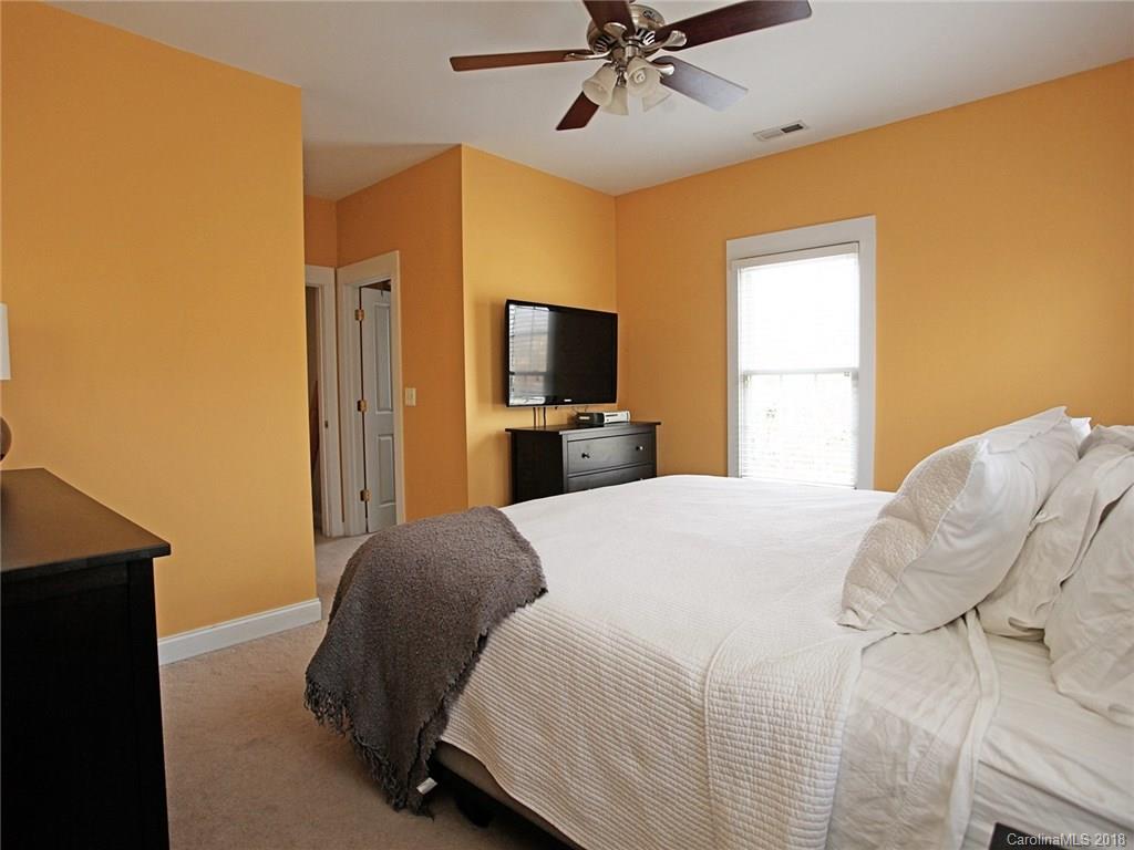 9399 Founders Street, Unit 164 Fort Mill, SC 29708 - Photo 18 of 36 a bedroom with a bed and a flat tv screen on dresser