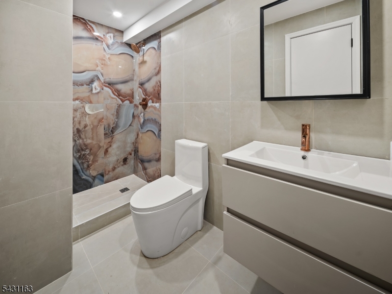 100 Chestnut Street, Unit 3 West Orange, NJ 07052 - Photo 9 of 18 a bathroom with a sink a toilet and shower