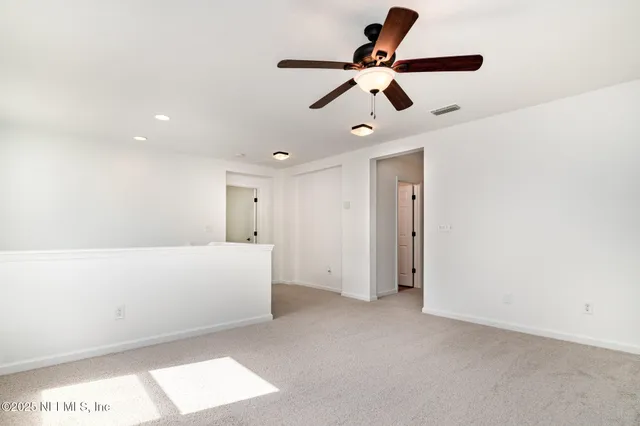 a living room with furniture and a ceiling fan