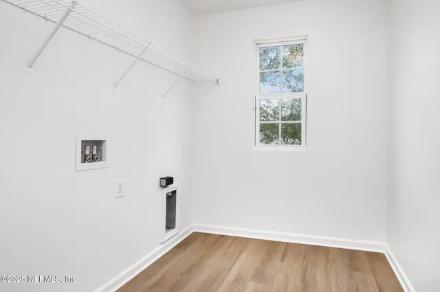 a view of a small space with wooden floor and a window