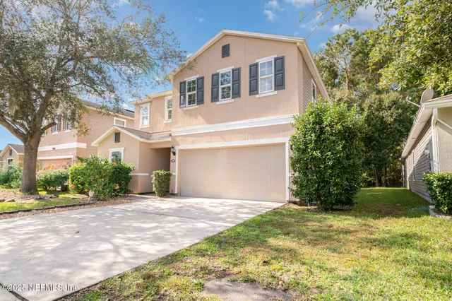 a front view of a house with a yard and garage