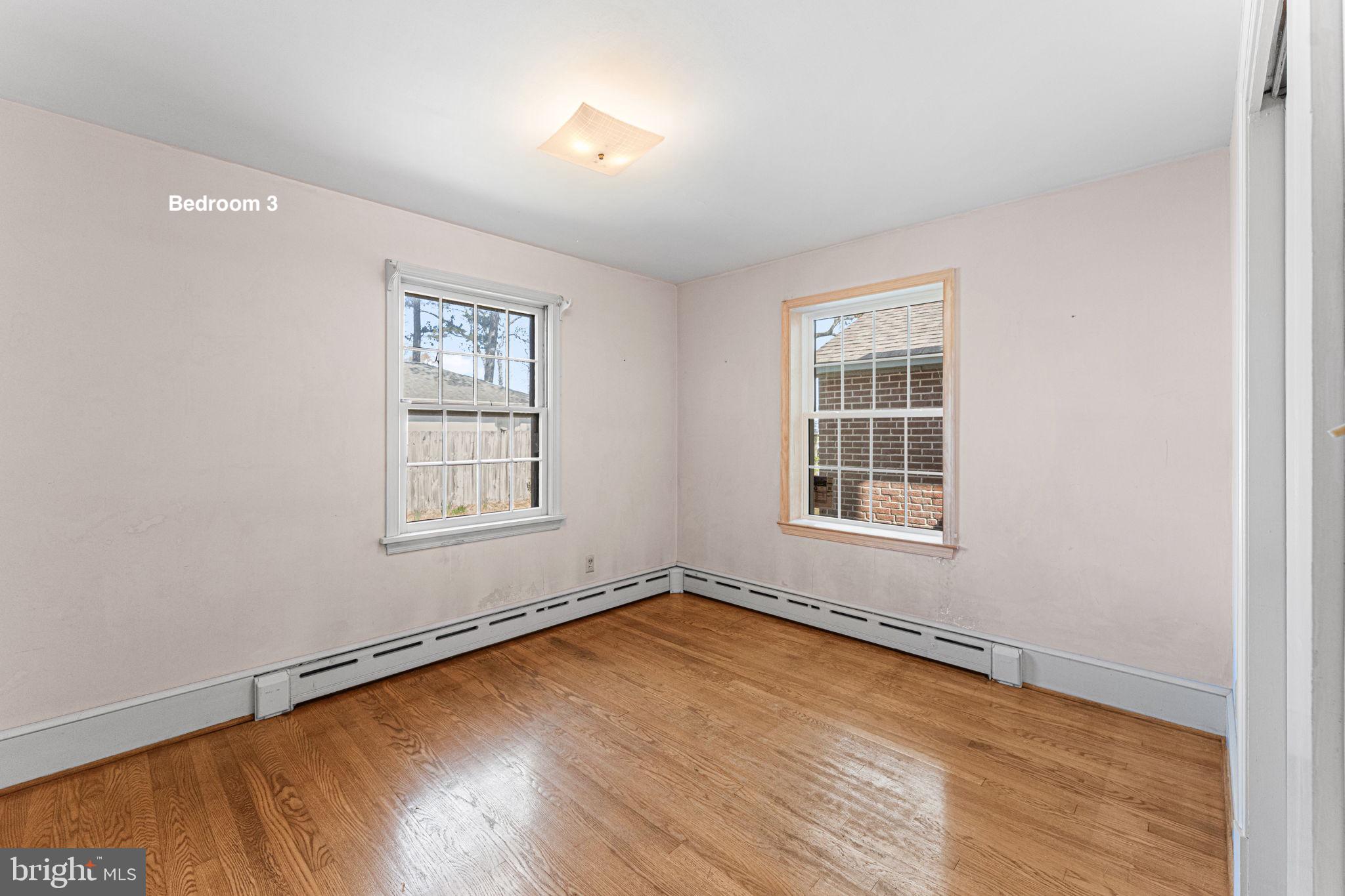 137 Pine Drive Reedville, VA 22539 - Photo 22 of 36 an empty room with wooden floor and windows