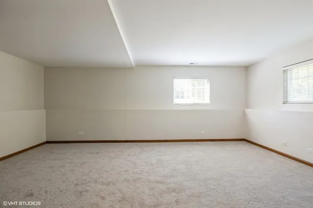 a view of an empty room with fire place and a window