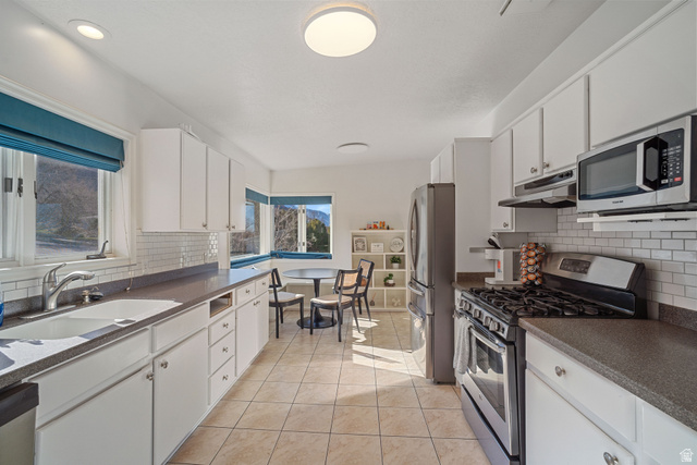 4426 South 3035 East Holladay, UT 84124 - Photo 6 of 49 Kitchen with stainless steel appliances, backsplash, and white cabinets