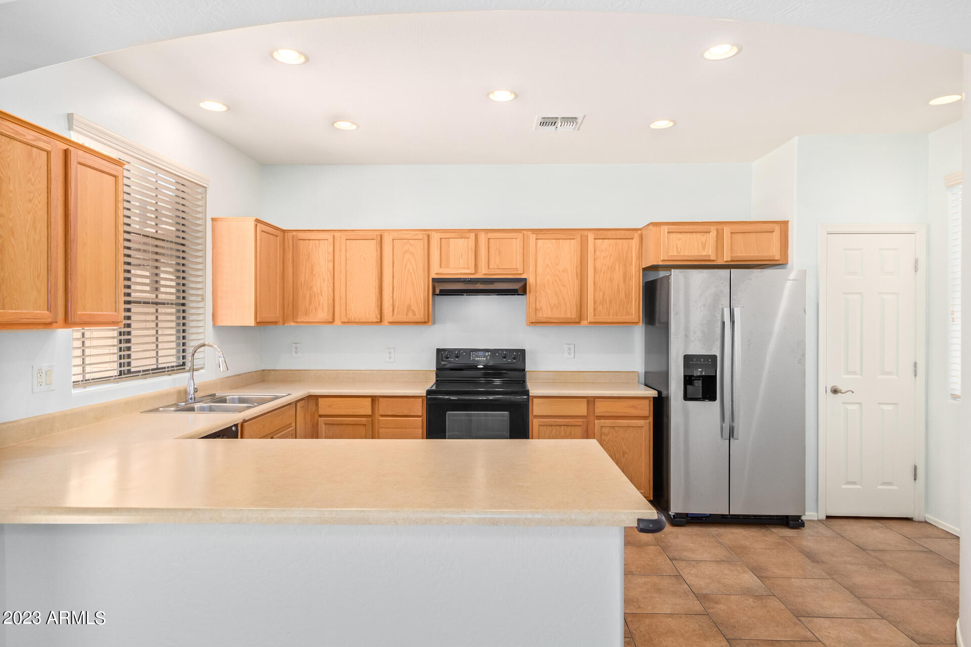 2390 West Sleepy Ranch Road Phoenix, AZ 85085 - Photo 8 of 27 a kitchen with stainless steel appliances granite countertop a refrigerator a stove and a sink with wooden cabinets
