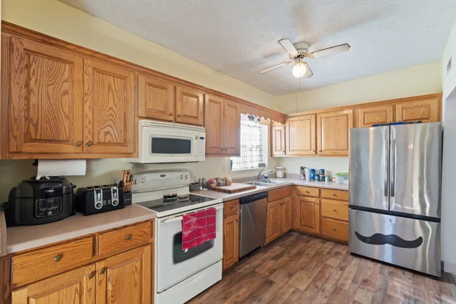 a kitchen with stainless steel appliances granite countertop a sink a stove and refrigerator