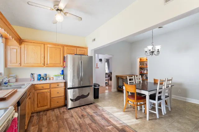 a kitchen with a table chairs refrigerator and cabinets