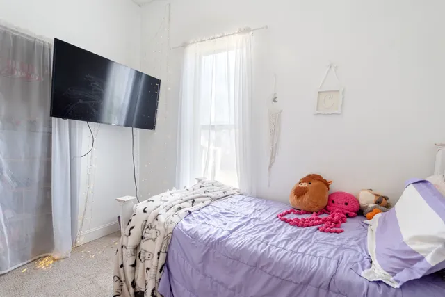 a bedroom with a bed and flat screen tv