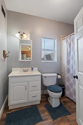 a spacious bathroom with a granite countertop toilet a sink and a mirror