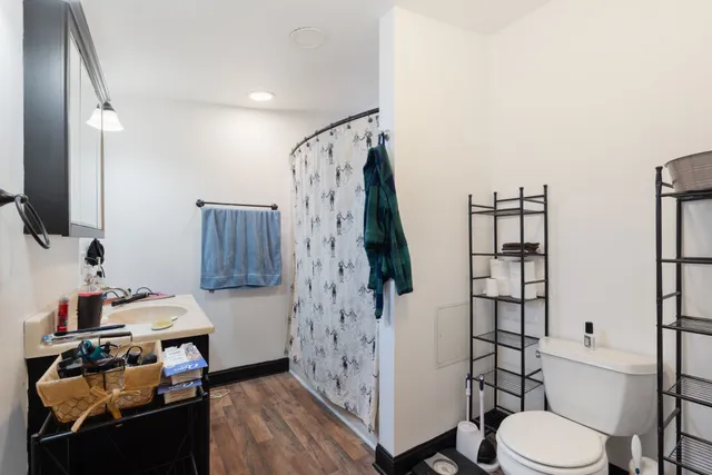 a bathroom with a toilet sink and shower curtain