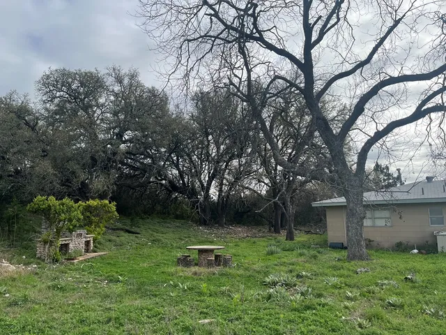 a backyard of a house with table and chairs