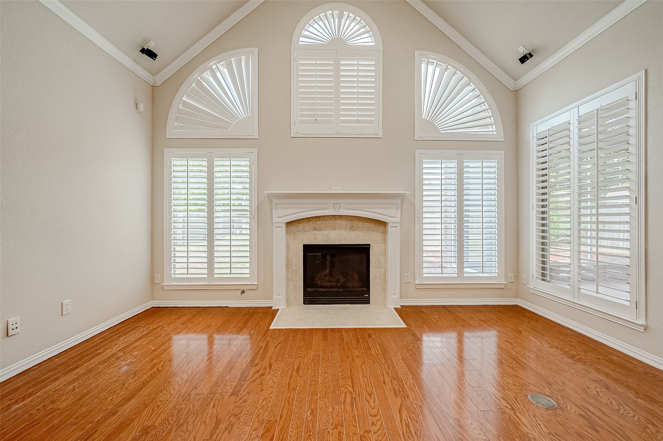 7206 Spring Meadow Lane Katy, TX 77494 - Photo 16 of 50 an empty room with wooden floor fireplace and windows