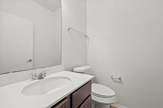 a bathroom with a sink a toilet and a mirror