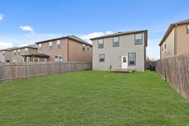 a view of a backyard with plants and wooden fence