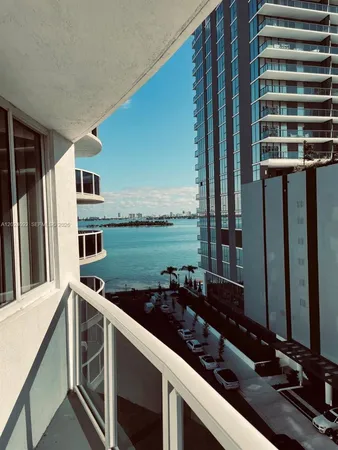 a view of a balcony with chairs and a floor to ceiling window