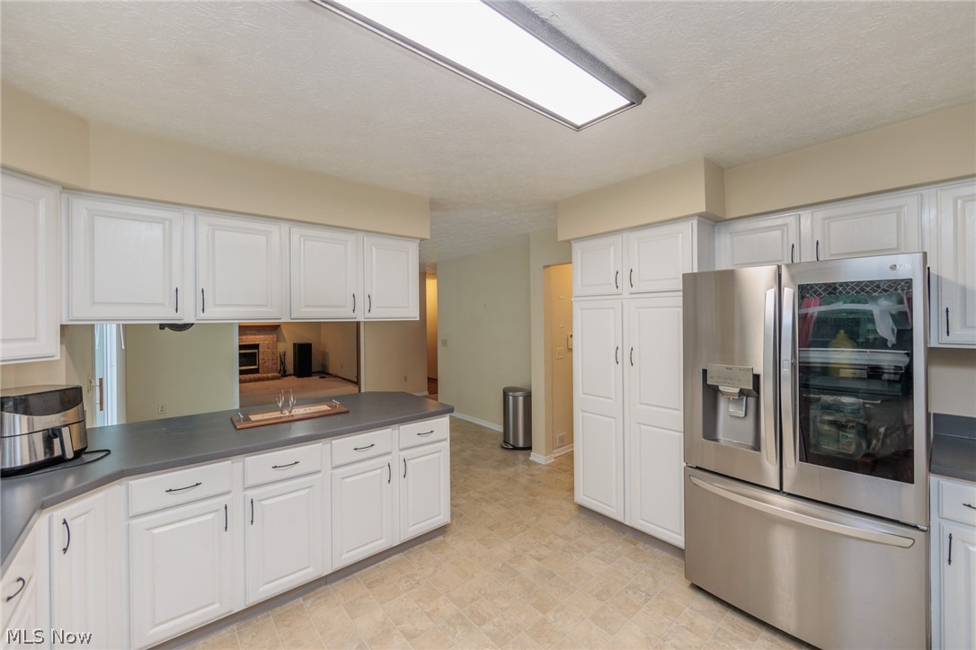 4123 Baird Road Stow, OH 44224 - Photo 14 of 47 Kitchen featuring stainless steel fridge with ice dispenser, light tile patterned flooring, and white cabinets