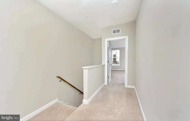 a view of a hallway with wooden floor and closet