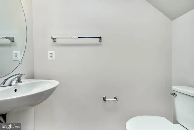 a bathroom with a sink mirror and toilet