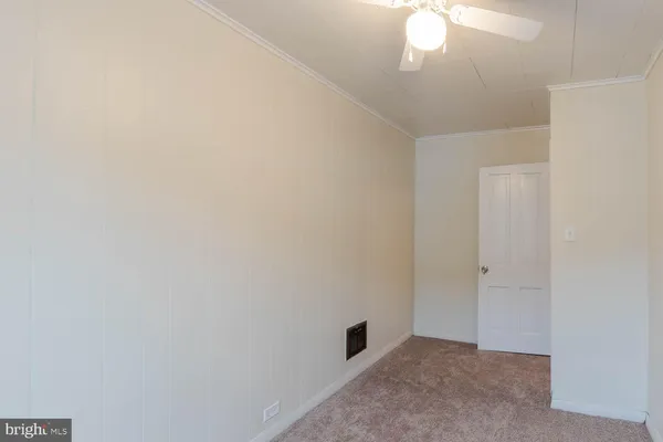 an empty room with a chandelier fan