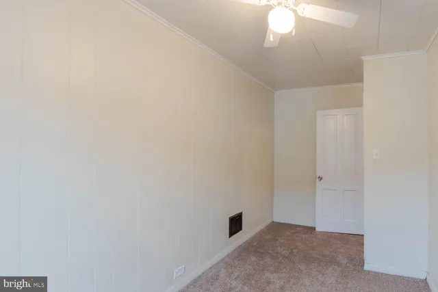 an empty room with a chandelier fan