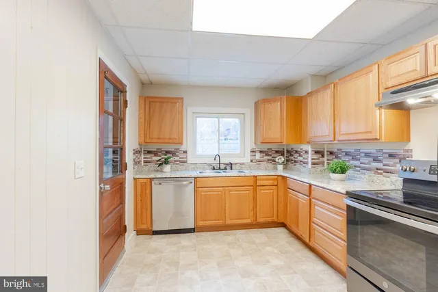 a kitchen with stainless steel appliances granite countertop a sink and cabinets