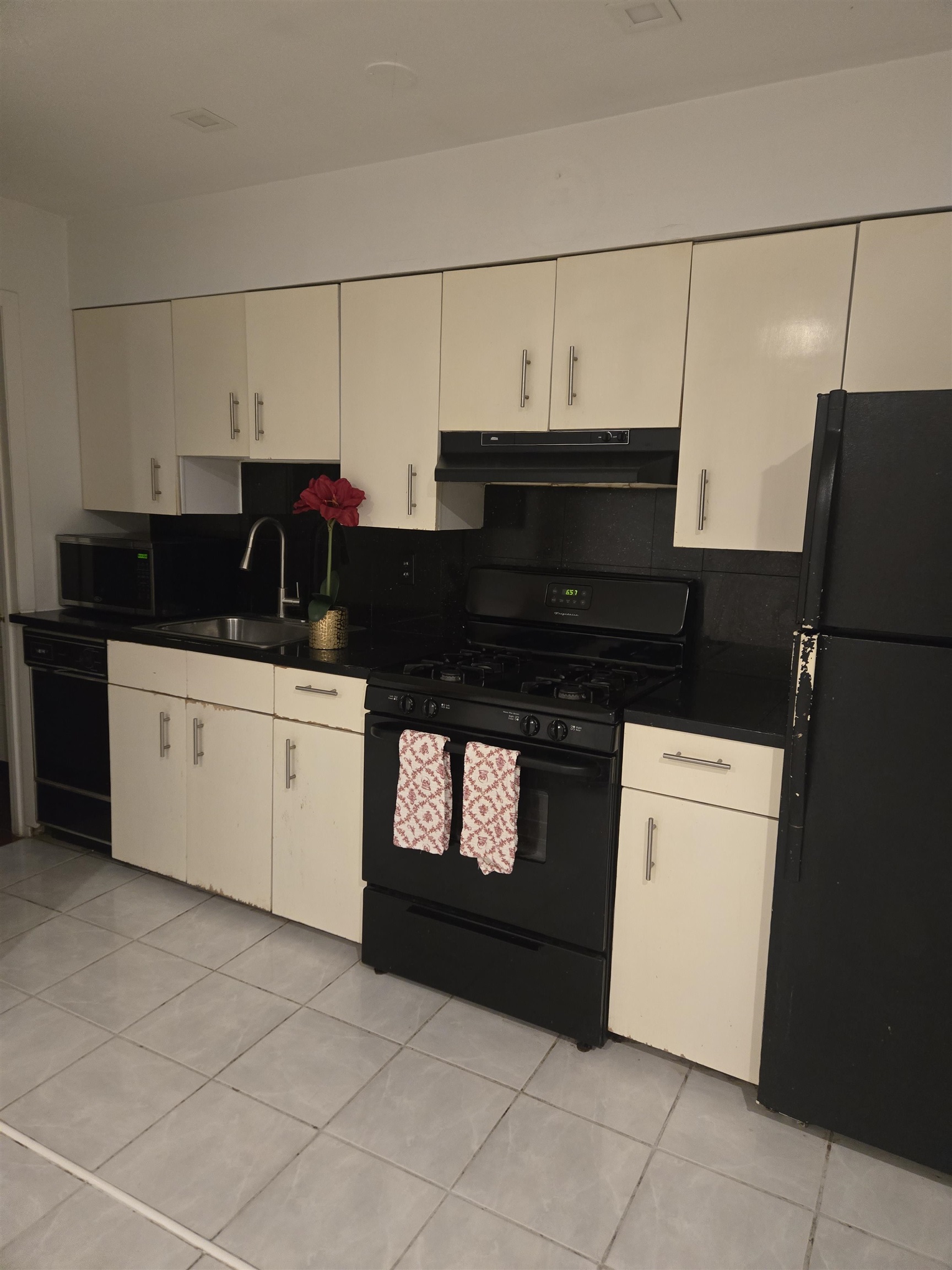 603 55th Street, Unit 312 West New York, NJ 07093 - Photo 3 of 10 a kitchen with granite countertop a sink and a stove