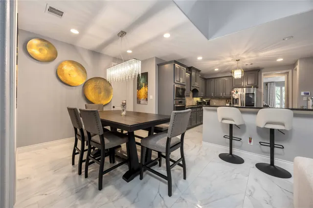 a kitchen with a dining table cabinets and chairs