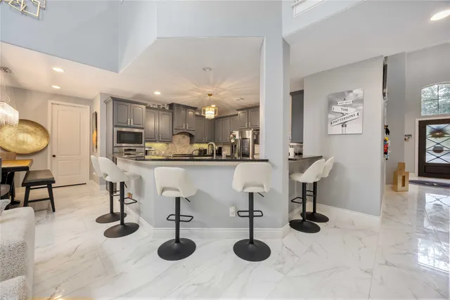 a kitchen with stainless steel appliances kitchen island granite countertop a sink and a white cabinets