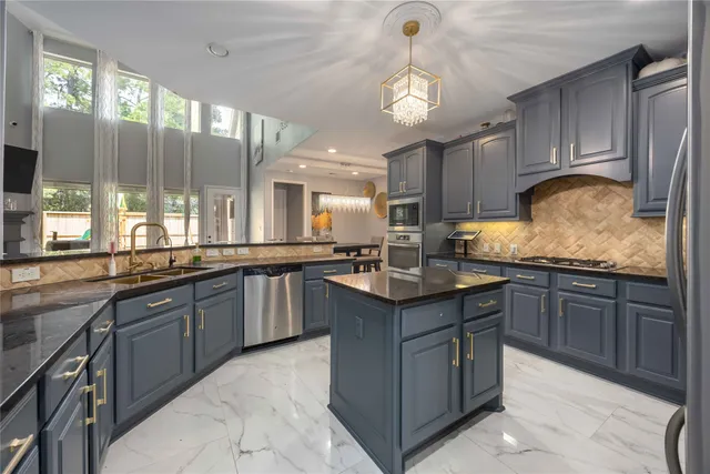 a kitchen with granite countertop a sink counter top space appliances and cabinets