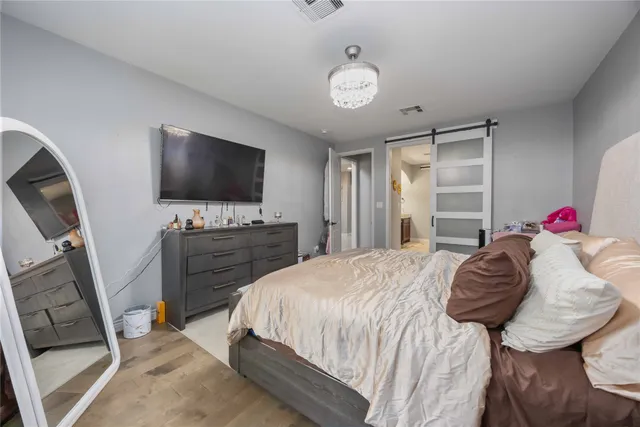 a spacious bedroom with a bed and a flat screen tv