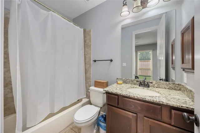 a bathroom with a granite countertop sink toilet and mirror